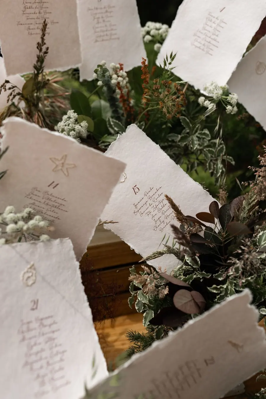 Seating plan en papel de algodón con los bordes rasgados, entre flores