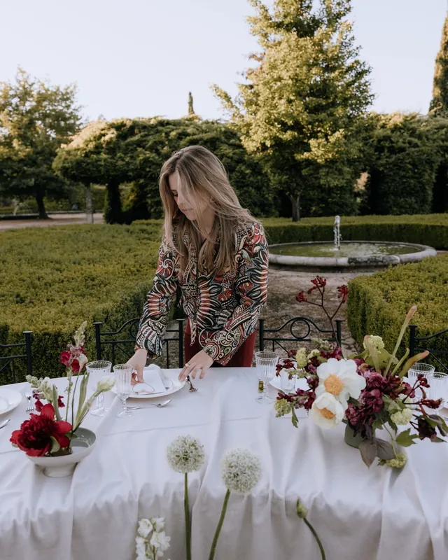 Montando una mesa con flores rojas en el jardín de un pazo